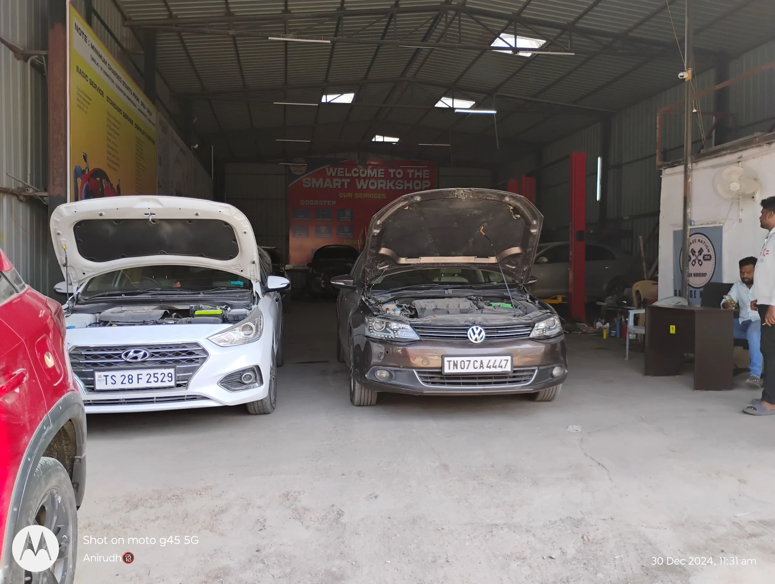 Mechanics checking and cleaning cars in garage
